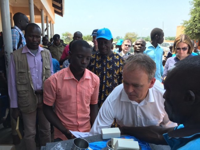Minister of State for International Development and the Diaspora Joe McHugh giving an emergency supply package to a newly arrived South Sudanese refugee at the Nyumanzi Refugee Transit centre in northern Uganda