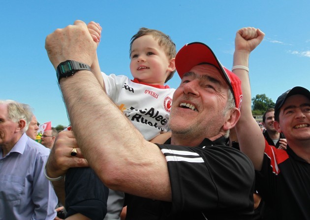Mickey Harte celebrates with his grandson Michael at the final whistle