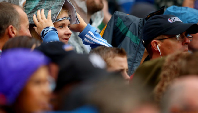 A Dublin fan shelters from the rain