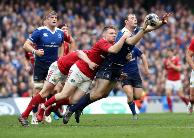 Leinster’s Robbie Henshaw is tackled by Munster’s Rory Scannell