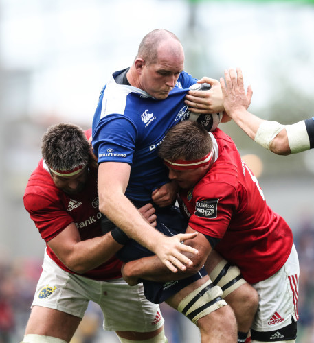 Leinster’s Devin Toner is tackled by Munster’s Billy Holland and CJ Stander