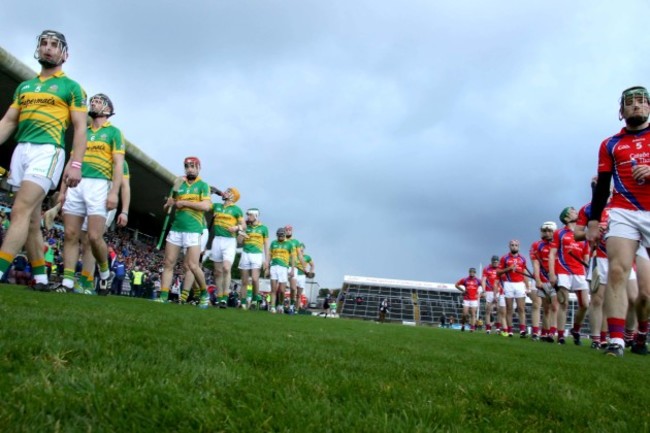 The teams march behind St Patrick's Brass band ahead of the game