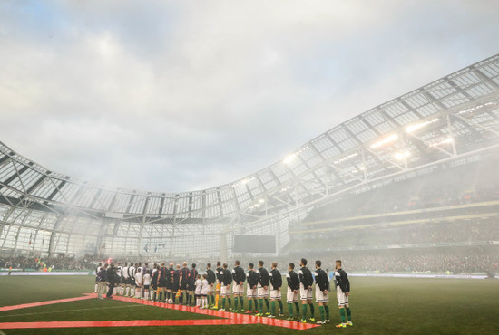 The two teams stand for the national anthem