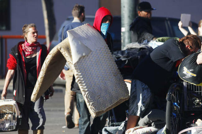 Unidentified man carries mat