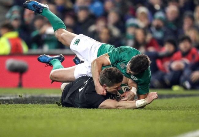 Beauden Barrett scores a try despite the efforts of Jonathan Sexton