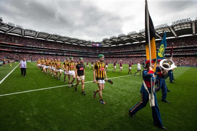 Kilkenny and Galway players walk behind the band