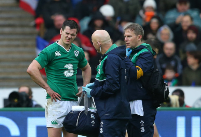 Jonathan Sexton leaves the pitch injured with Jim McShane and James Allen