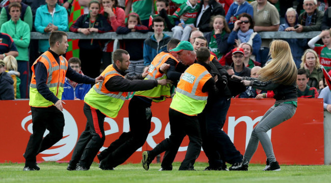 A Mayo supporter is led from the pitch