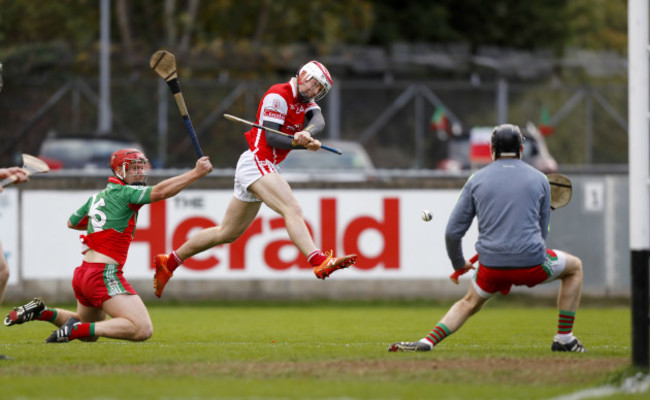 Con O'Callaghan scores a goal despite the tackle of Jim Fitzpatrick