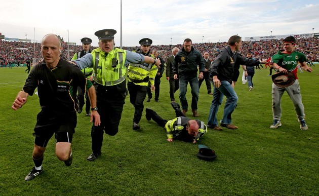 Cormac Reilly leaves the field with a garda escort after the game