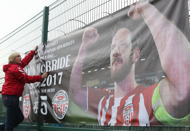 Karen Pyne erects a banner in tribute to late captain Ryan McBride