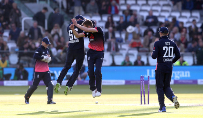 Mark Wood celebrates with a leap with Joe Root after he bowls George Dockrel to win the match