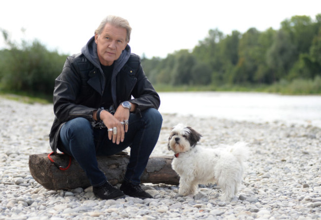 dpa-exclusive - Johnny Logan sits at Isar river with his dog