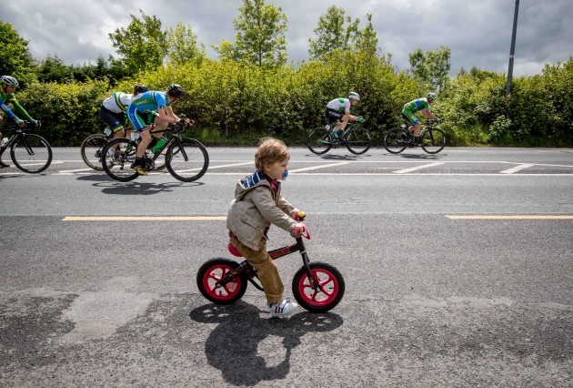 2 year old Fionn Carter tries to keep up with the peleton as they come into the town