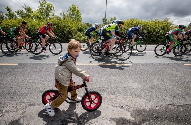2 year old Fionn Carter tries to keep up with the peleton as they come into the town