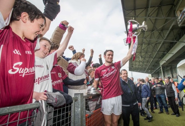 Fans celebrate with Galway captain David Burke and the Division 1 trophy