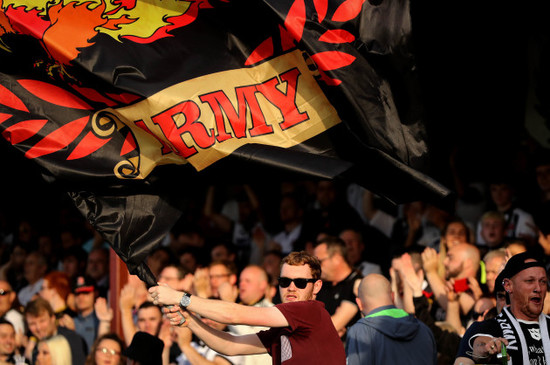 A Dundalk fan waves a flag as the team come out