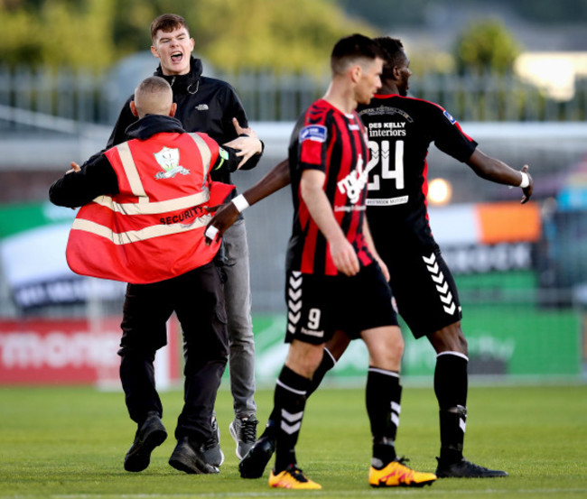 IshMahli Akinade celebrates scoring as a fan runs on to the pitch