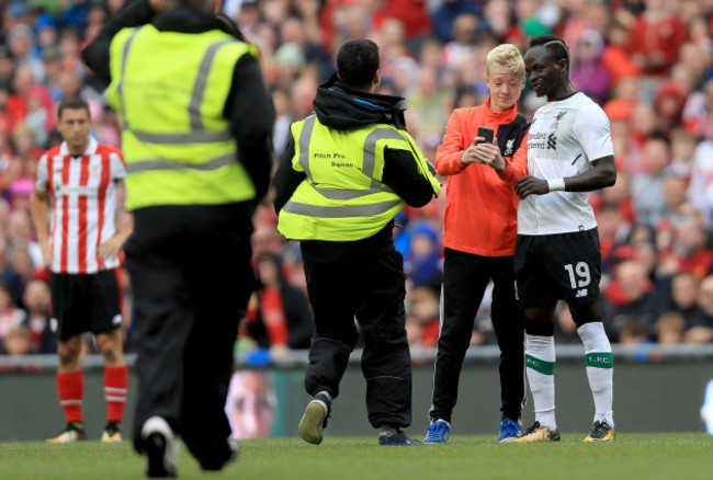A supporter attempt's to get a selfie with Liverpool's Sadio Man&eacute; as security run on to the pitch