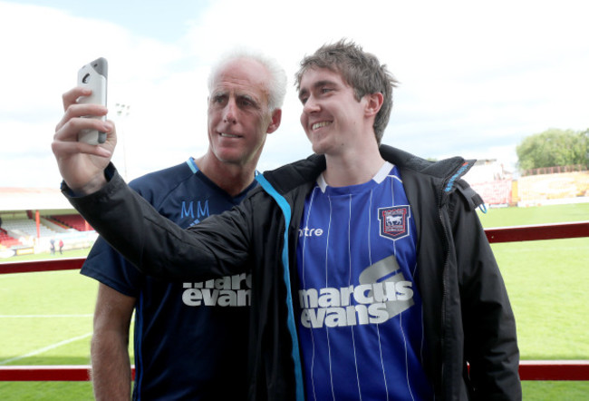 Mick McCarthy poses with a fan after the game