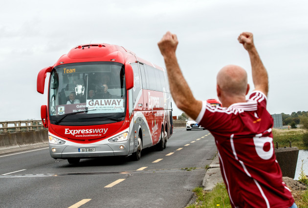 The Galway team bus with the Liam McCarthy Cup pass over the River Shannon as Timmy O Flatharta salutes the team