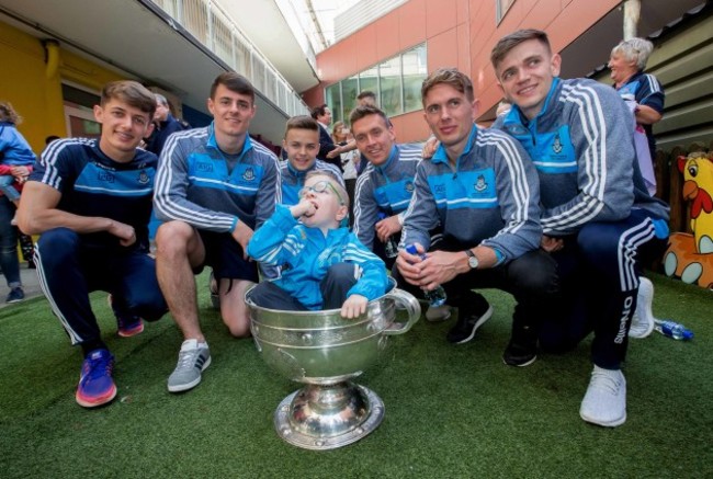Liam Collins sits in the Sam Maguire with Evan Comerford, Brian Howard, Eoin Murchan, Mark Schutte, Michael Ftizsimons and Cillian O'Shea