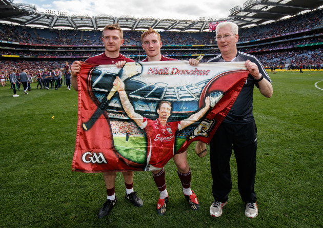 Joe Canning, Conor Whelan and Tex Callaghan with a flag in memory of Niall Donohue