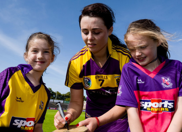 Mary Leacy signs hurleys for young fans after the game
