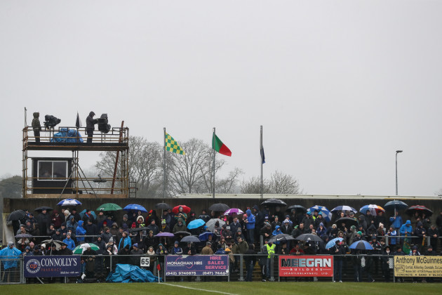 Fans await the start of the game in wet conditions
