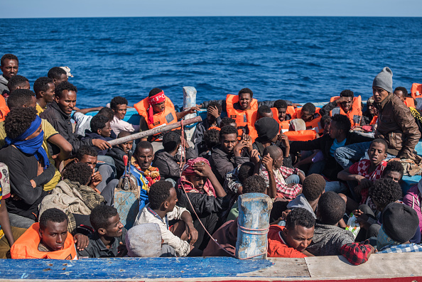 Migrants seen packed in their boat crossing the ocean into