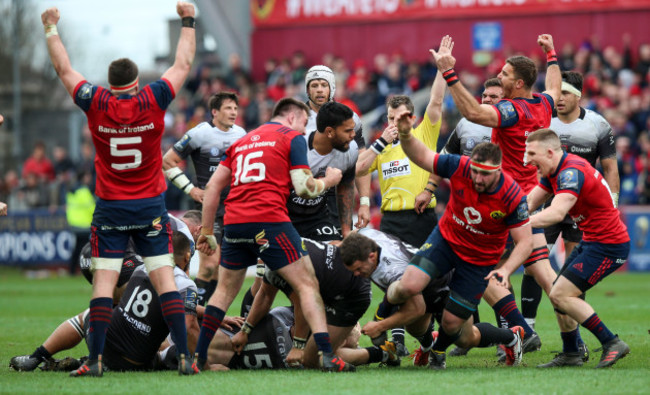 Munster players celebrate as referee Nigel Owens awards a penalty to finish the game