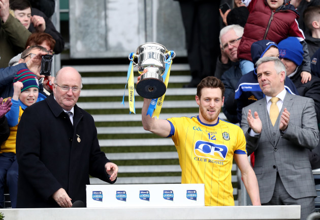 Conor Devaney accepts the trophy from John Horan