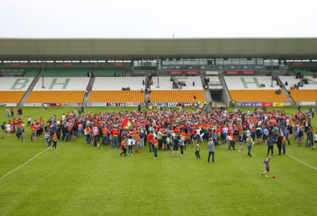 Carlow supporters celebrate on the pitch after the game