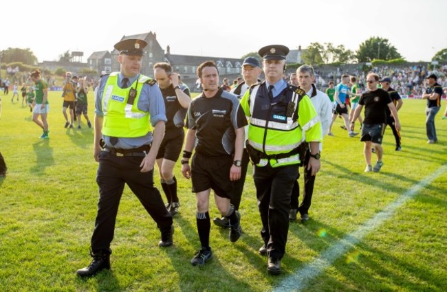 Paddy Neilan is escorted off the field at the full time whistle