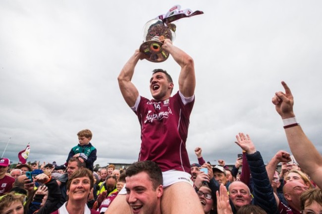 Damien Comer celebrates after the game with the trophy