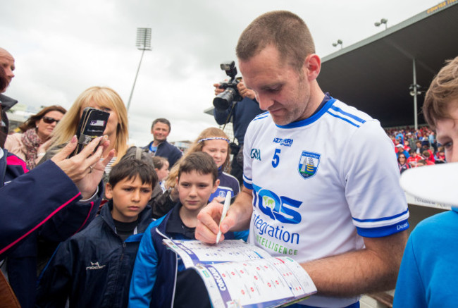 Michael Walsh signs a fans programme after the game