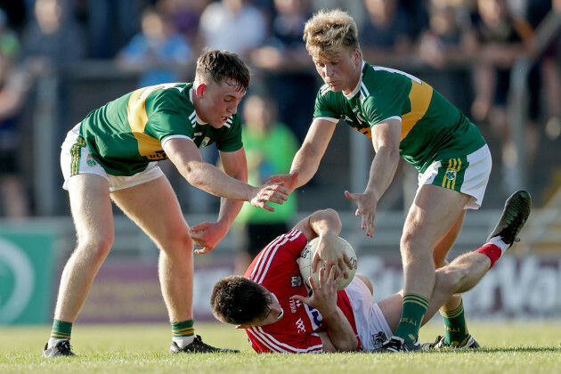 Tadhg Corkery tackled by Dara Moynihan and Fiachra Clifford