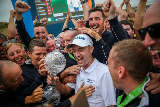 Russell Knox celebrates with green keepers on the 18th green