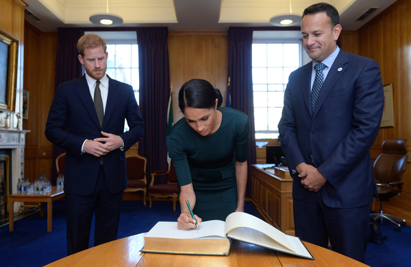 Britain's Prince Harry and his wife Meghan, the Duke and Duchess of Sussex, sign the visitors book in the office of the Taoiseach Leo Varadkar, at the start of a two-day visit to Dublin