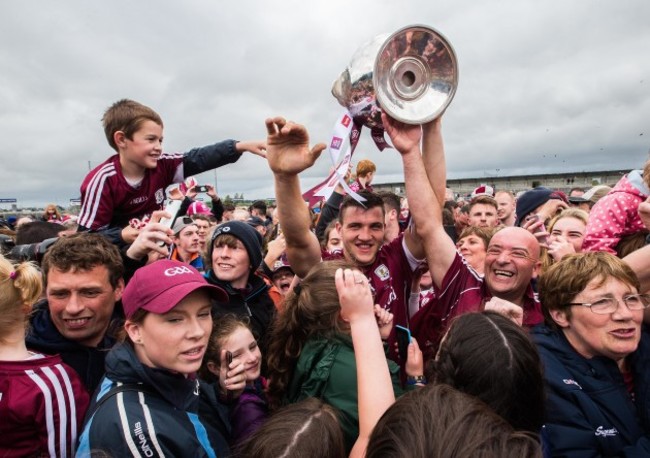 Damien Comer celebrates after the game with the trophy