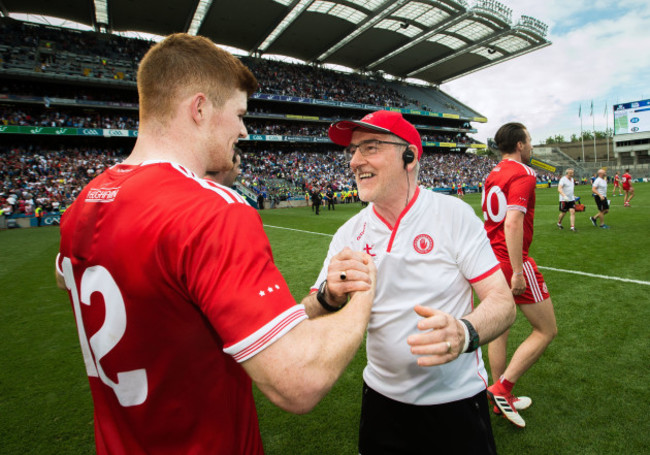 Mickey Harte celebrates at the final whistle with Cathal McShane
