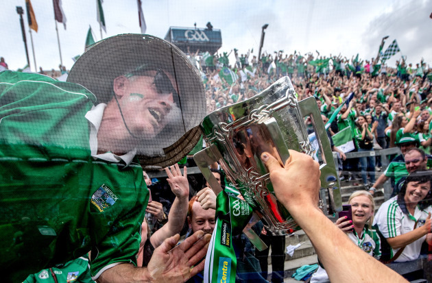 A Limerick fan kisses the Liam McCarthy Cup through the glass on Hill 16