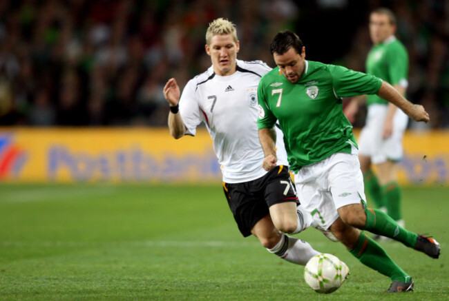Bastian Schweinsteiger of Germany with Andy Reid of Irelannd