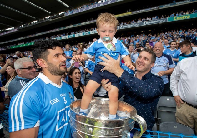 Kevin McManamon's nephew, 2 year old Liam McManamon is lifted into the Sam Maguire alongside Dublin's Cian O'Sullivan