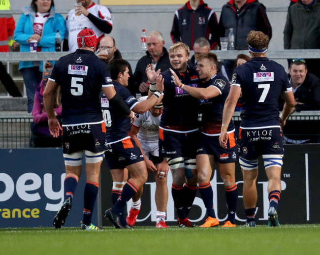 Tom Brown celebrates scoring a try with teammates