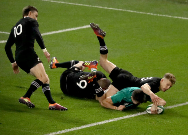 Jacob Stockdale scores a try despite the efforts of Aaron Smith and Damian McKenzie