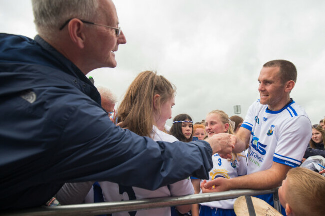 Michael Walsh shakes hands with a fan after the game