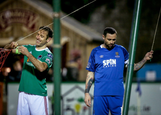 Alan Bennett and Damien Delaney fix the goal net during the game