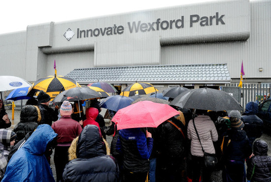 Spectators arrive at the ground in the rain