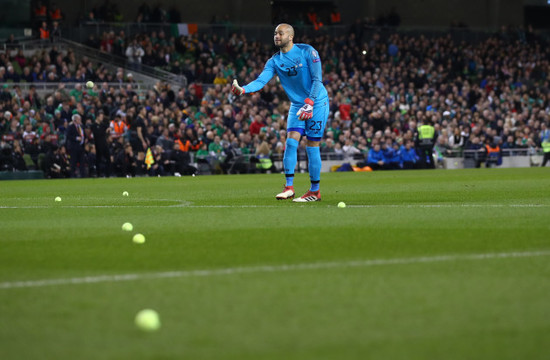 Darren Randolph removes tennis balls from the field